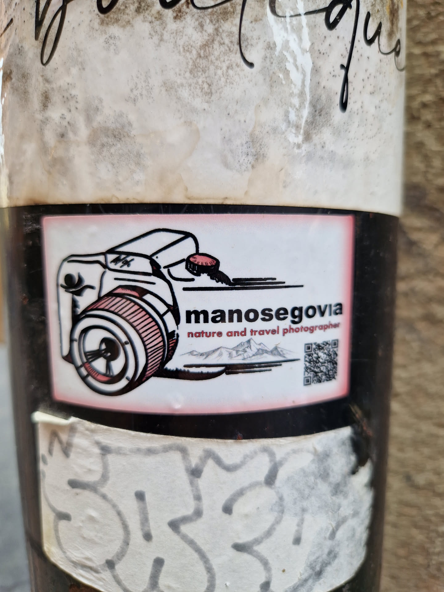 Sticker featuring a drawing of a camera, mountains, and a QR code. The text manosegovia nature and travel photographer is visible. 