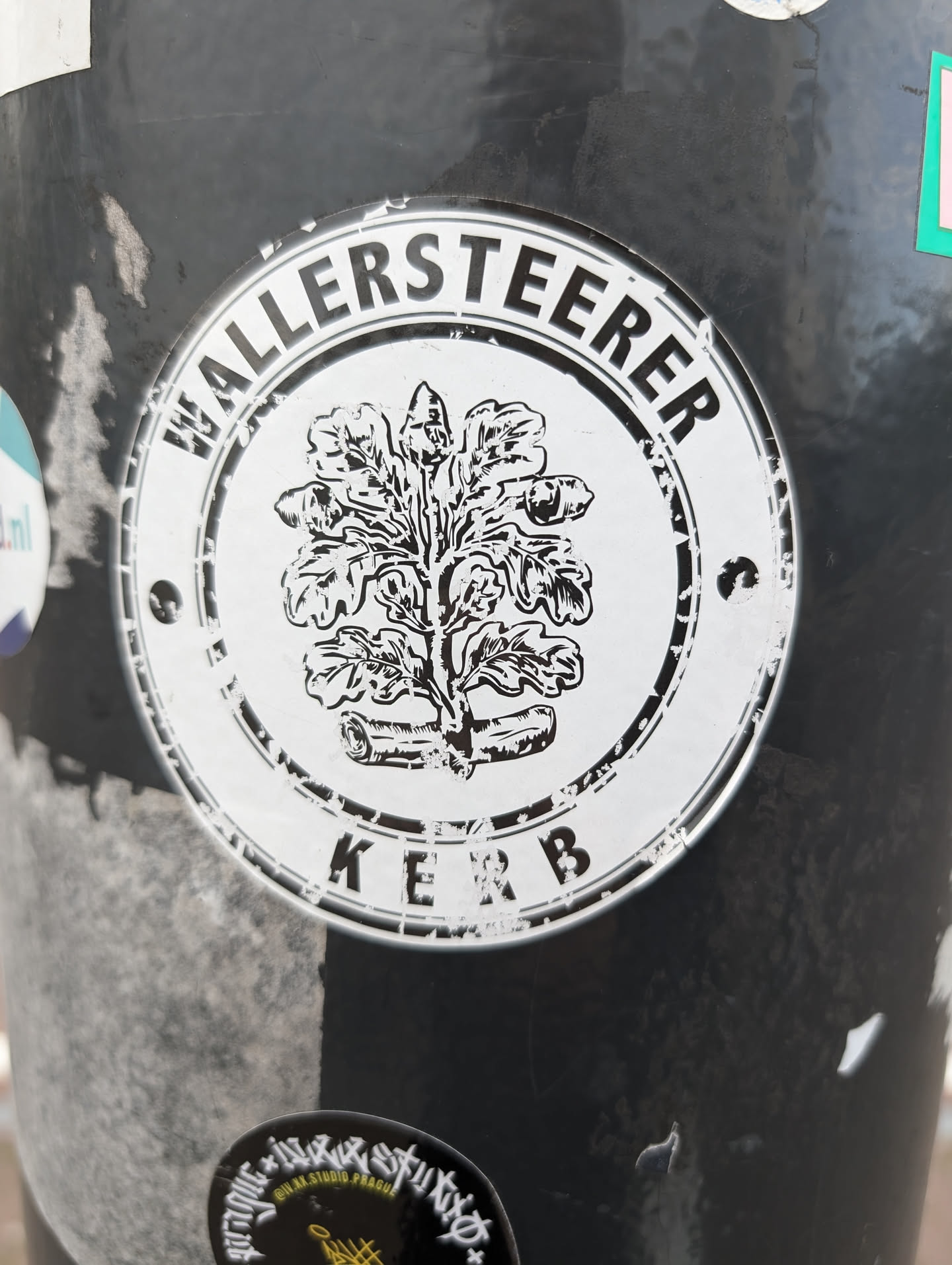 Black and white sticker with a circular design. It features an oak tree emblem in the center, surrounded by text that reads "WALLERSTEERER" at the top and "KERB" at the bottom. The style is simple and classic, possibly representing a local event or community.