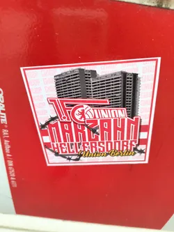A sticker featuring buildings above the text "FC UNION MARZAHN HELLERSDORF Union Berlin". The text is stylized and has barbed wire around it.