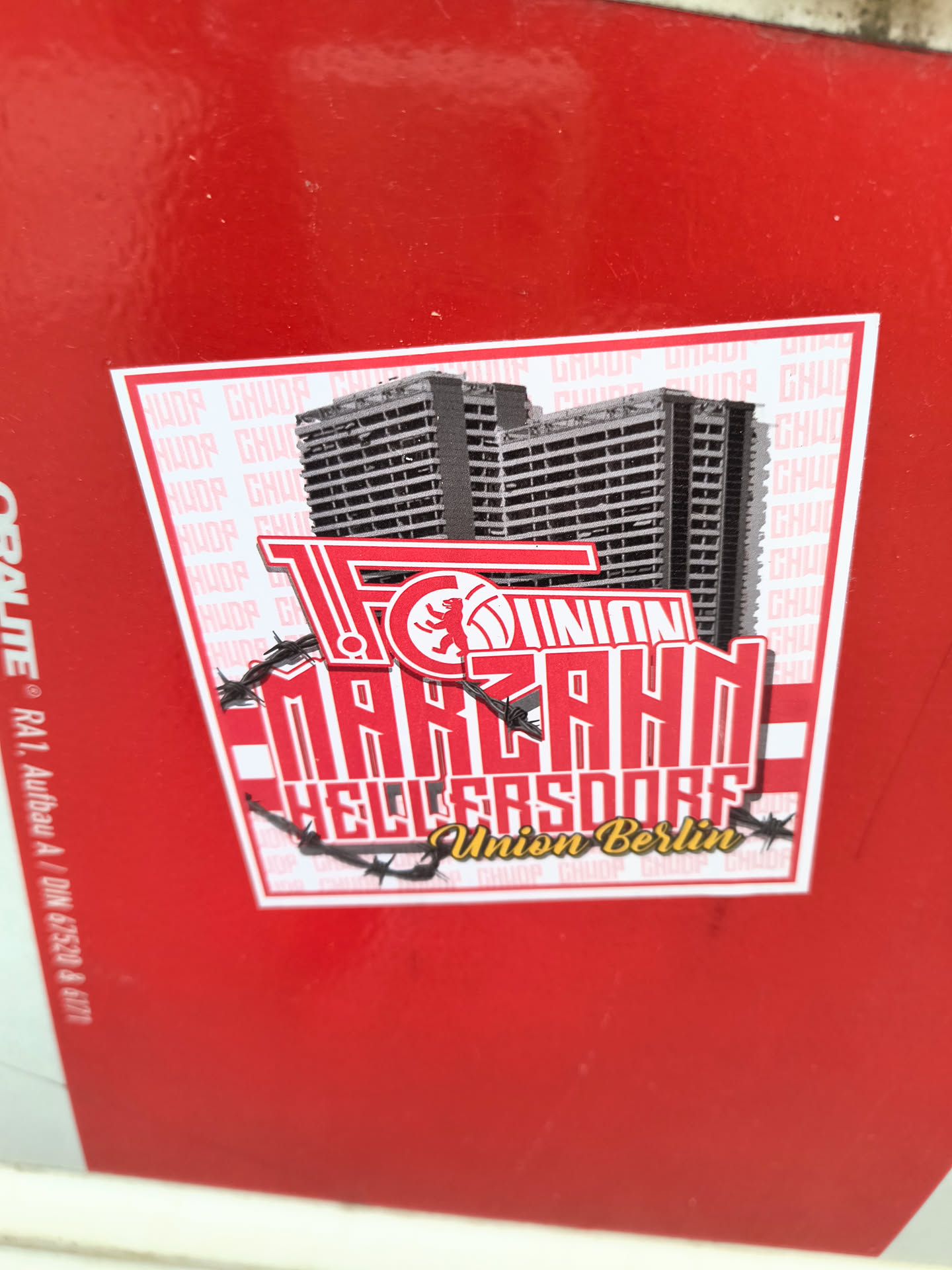 A sticker featuring buildings above the text "FC UNION MARZAHN HELLERSDORF Union Berlin". The text is stylized and has barbed wire around it.