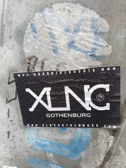 A black and white sticker with the logo XLNC and the text Gothenburg. The website www.xlncgothenburg.com is also printed on the sticker. 