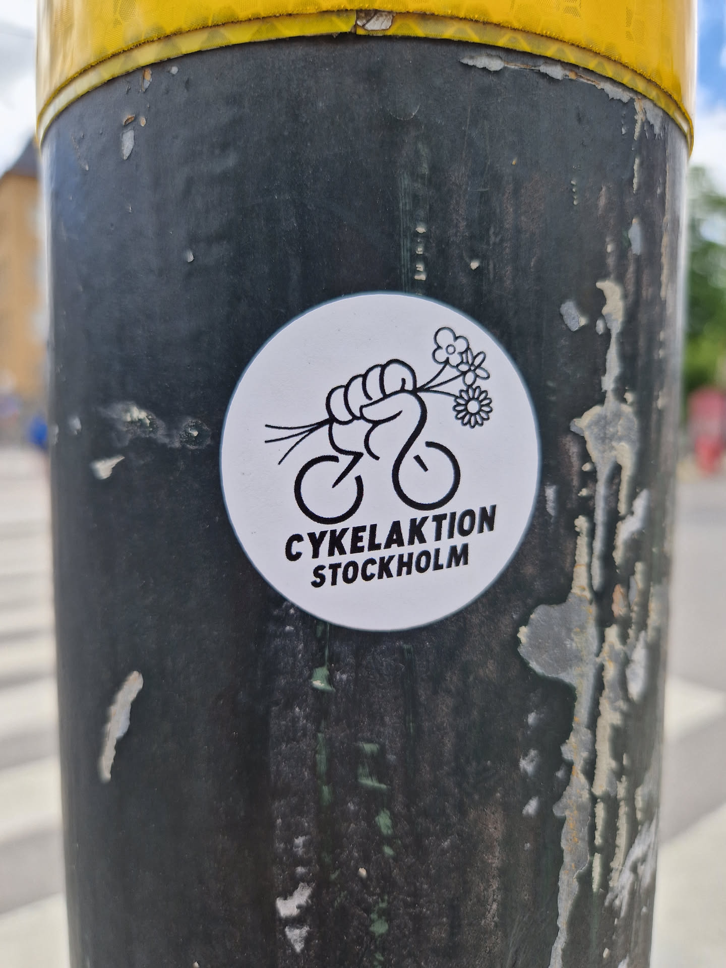 A sticker featuring a fist holding flowers above a bicycle. The text below says "Cykelaktion Stockholm".