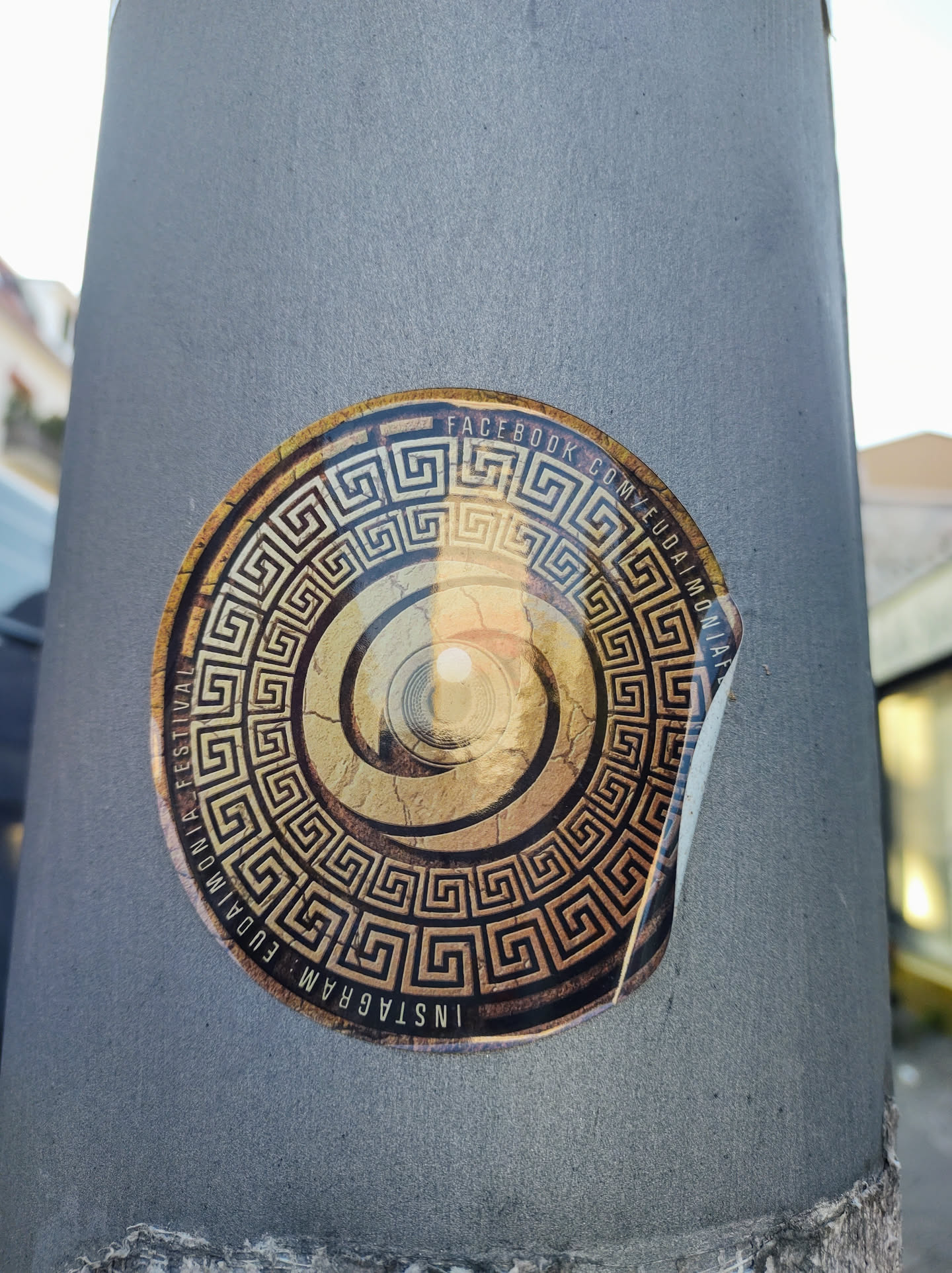 Round sticker featuring a spiral design encircled by a Greek key border. The text on the sticker indicates Facebook and Instagram social media links for  Euphoria Festival.