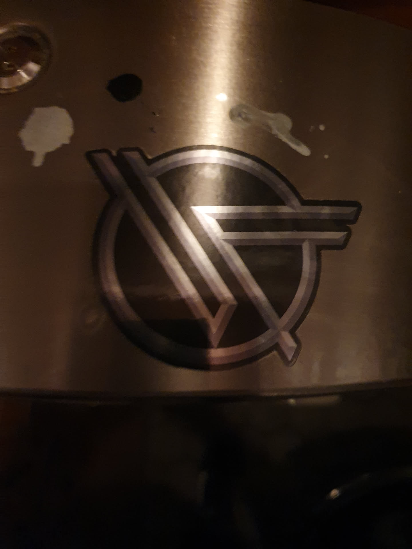 A sticker featuring the iconic Van Halen logo. The logo is in black and silver with a circular design.
