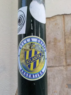 The sticker features a crest-like design with a yellow background and blue stripes. The word "ATLANTA" is prominently displayed in blue. The text "VILLA CRESPO ARGENTINA" surrounds the crest.