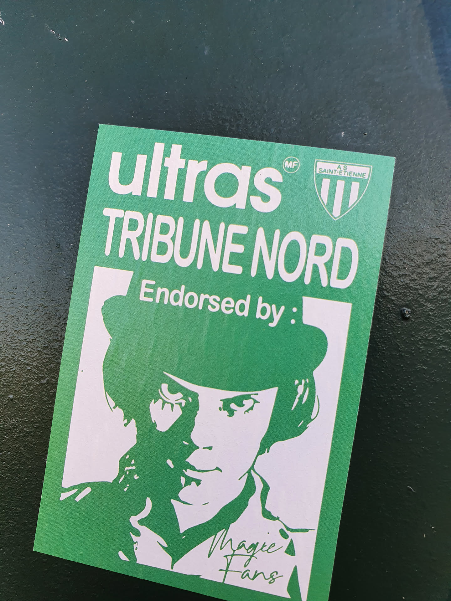 Green and white sticker featuring a stylized portrait of a person wearing a bowler hat, reminiscent of a character from the movie A Clockwork Orange.  The sticker also includes the text "Ultras TRIBUNE NORD" and "Endorsed by:" with the signature of "Magic Fans". A small logo for AS Saint-Étienne is present.