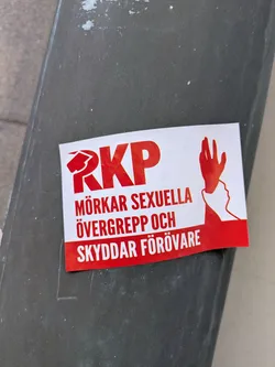 The sticker is red and white and features the text "RKP MÖRKAR SEXUELLA ÖVERGREPP OCH SKYDDAR FÖRÖVARE" along with a logo of RKP and a graphic of a hand silencing a face.