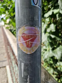 A vintage-looking sticker featuring the logo of Kalmar FF, a Swedish football club.  The sticker is affixed to a metal pole outdoors and appears slightly weathered.
