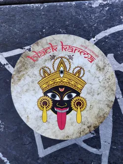 Round sticker featuring Kali, the Hindu goddess. The sticker has a distressed, vintage look and features the text "Black Karma" in stylized lettering.  The goddess Kali is depicted with her characteristic fierce expression, crown, and tongue.