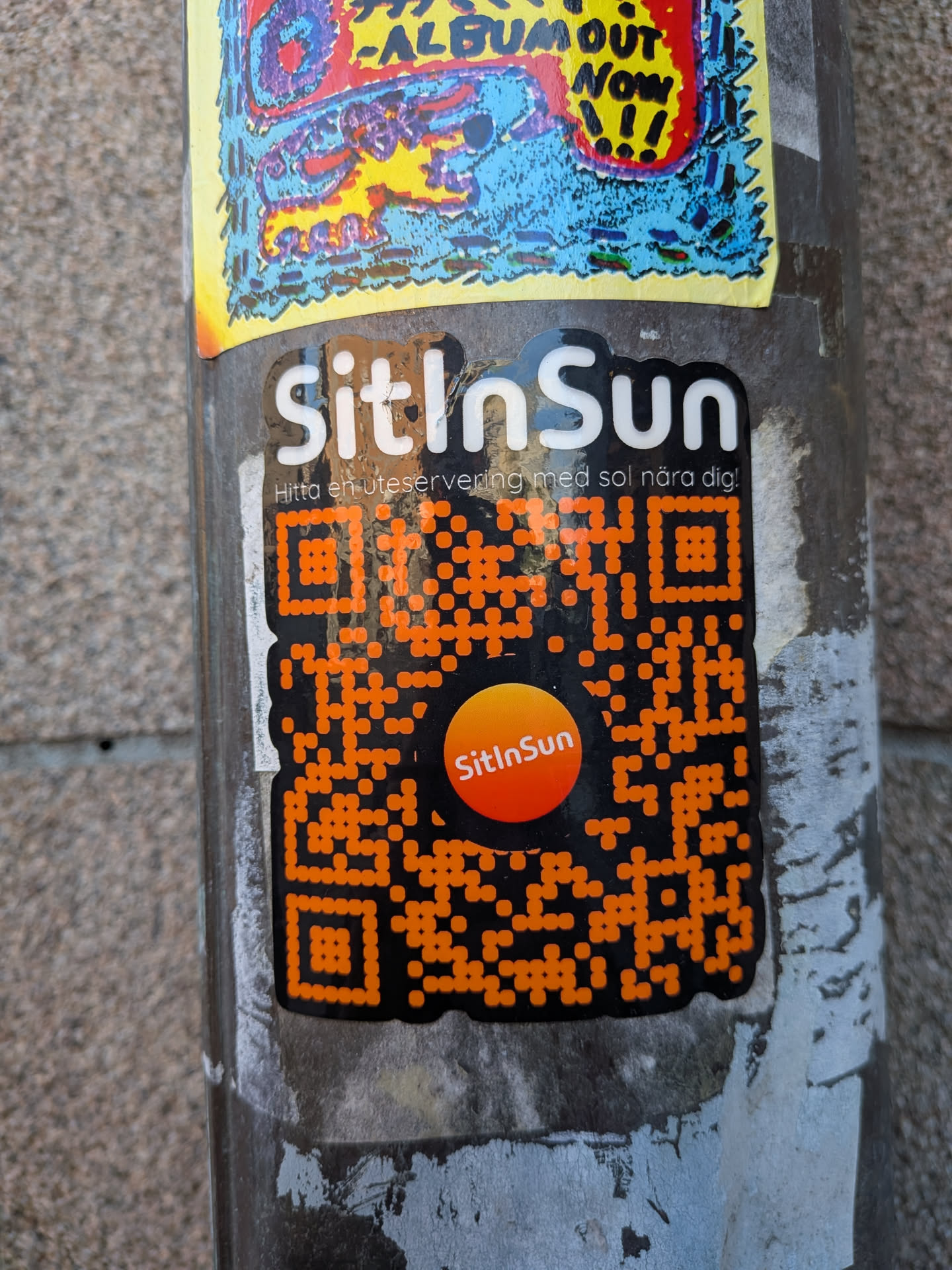 A vertically oriented die-cut sticker set against a black background with a white border. At the top, the bold white text reads 'SitInSun' accompanied by a Swedish tagline in smaller font: 'Hitta en uteservering med sol nära dig!'. Beneath the text is a prominent orange dot-matrix style QR code featuring an orange circular sun emblem in the center with the brand name 'SitInSun' written in white inside.