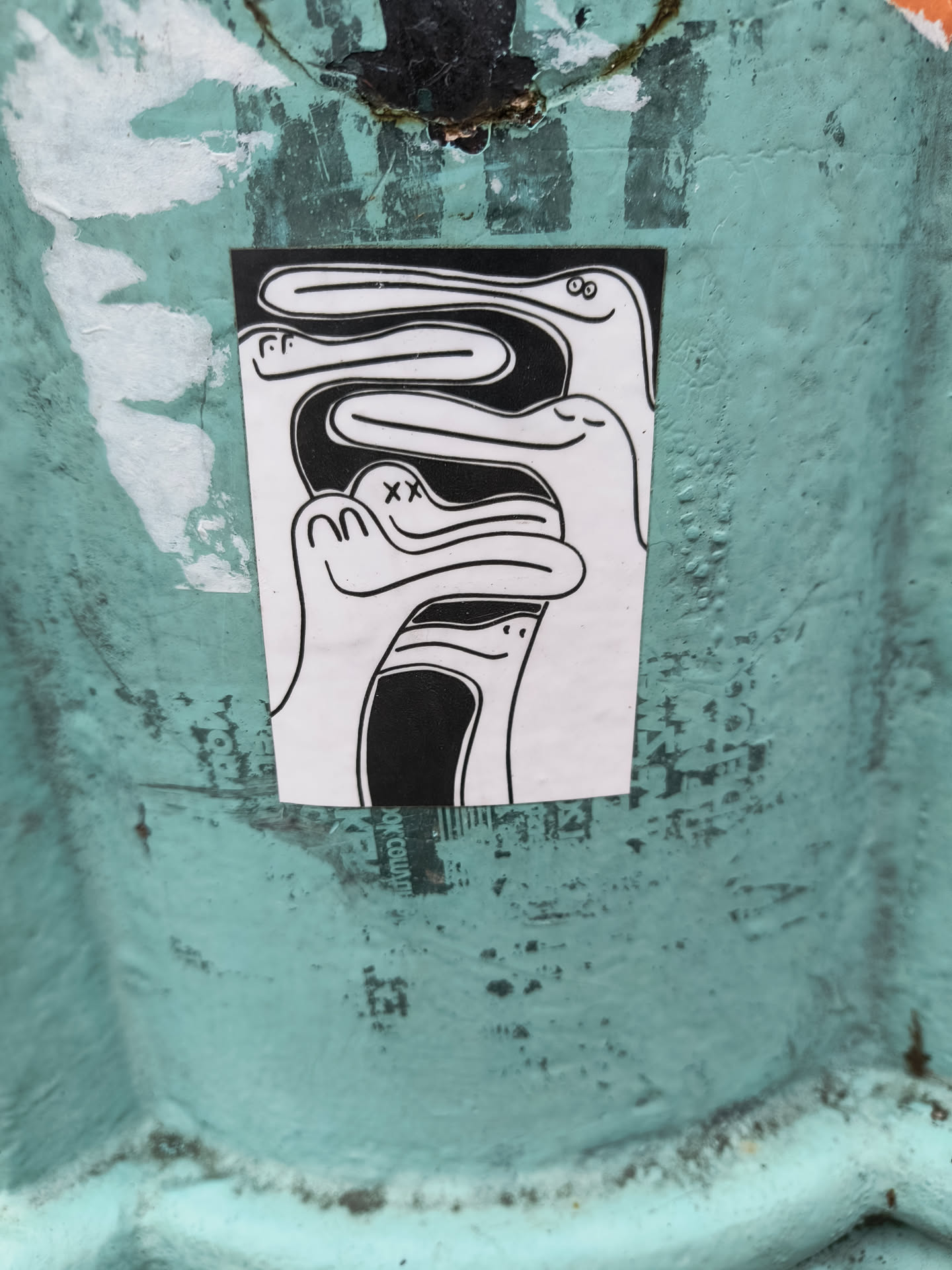 This sticker features a captivating design of several abstract figures intertwined together, creating a sense of unity and connection. The style is minimalist, with only black lines on a white background, lending a clean and modern feel. The figures have simple, almost childlike features, which adds a touch of whimsy. The overall impression is one of playfulness and subtle mystery, drawing the viewer into its abstract narrative.