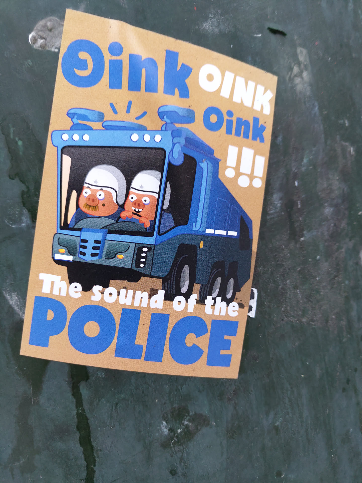 Sticker featuring a cartoon illustration of two pigs in a police car. The text on the sticker says "Oink Oink Oink!!! The sound of the POLICE".