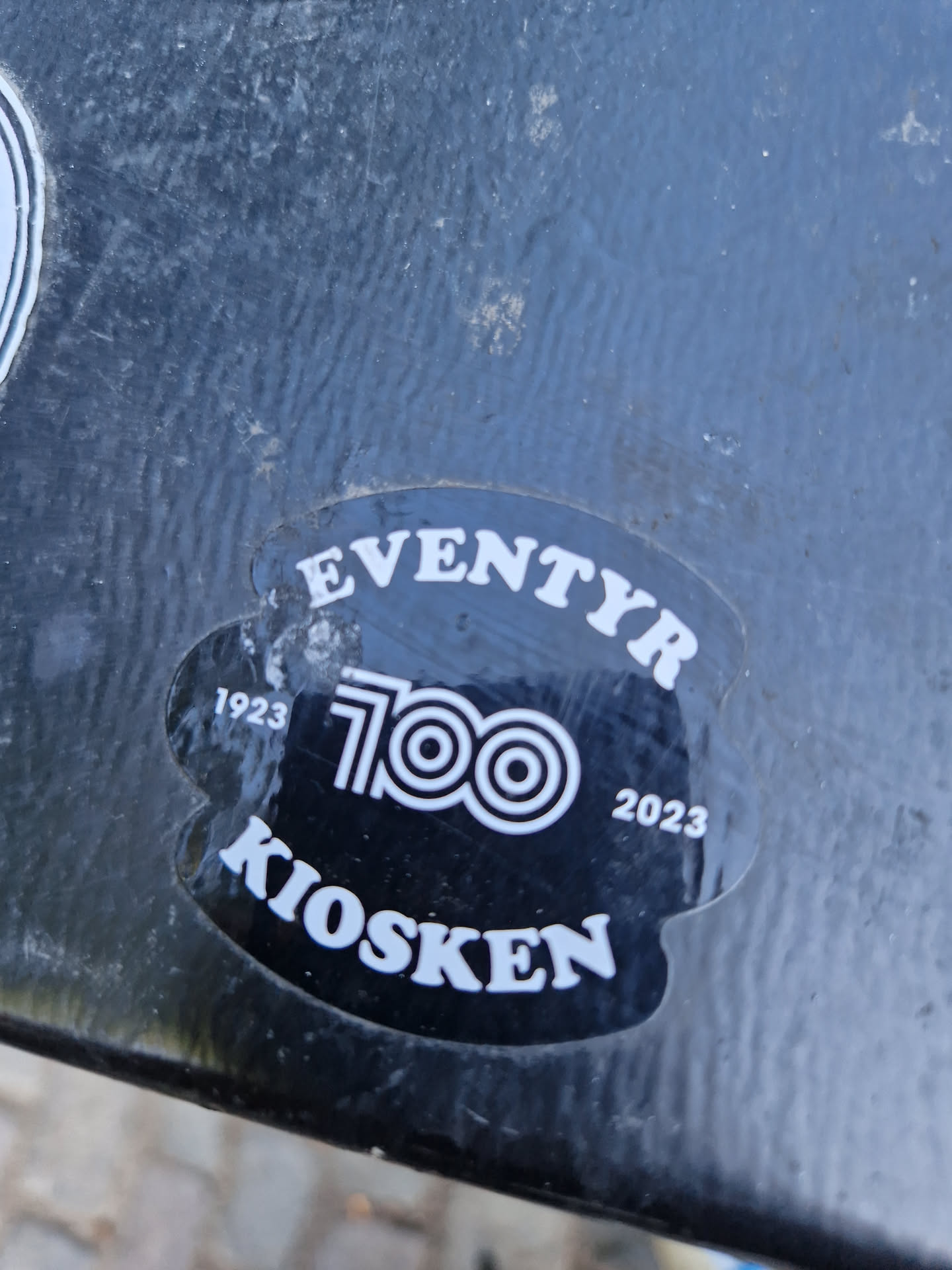 Black and white sticker commemorating the 100th anniversary of Eventyr Kiosken (1923-2023).