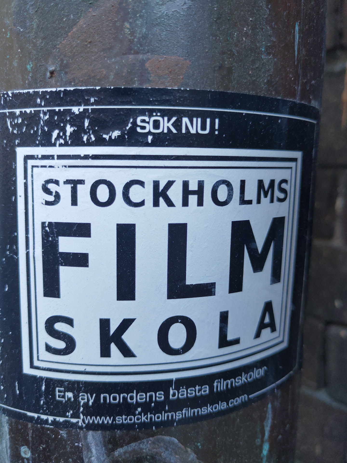 A sticker for Stockholm Film Skola, one of the best film schools in the Nordic region.  The sticker features the school's logo and website address. The text also says "Sök nu!" which means "Apply now!" in Swedish.