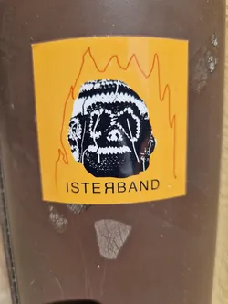 A sticker featuring a black and white illustration of a head engulfed in flames. The head has a textured pattern and the word \"ISTERYBAND\" is written below it in a stylized font. The background of the sticker is yellow.