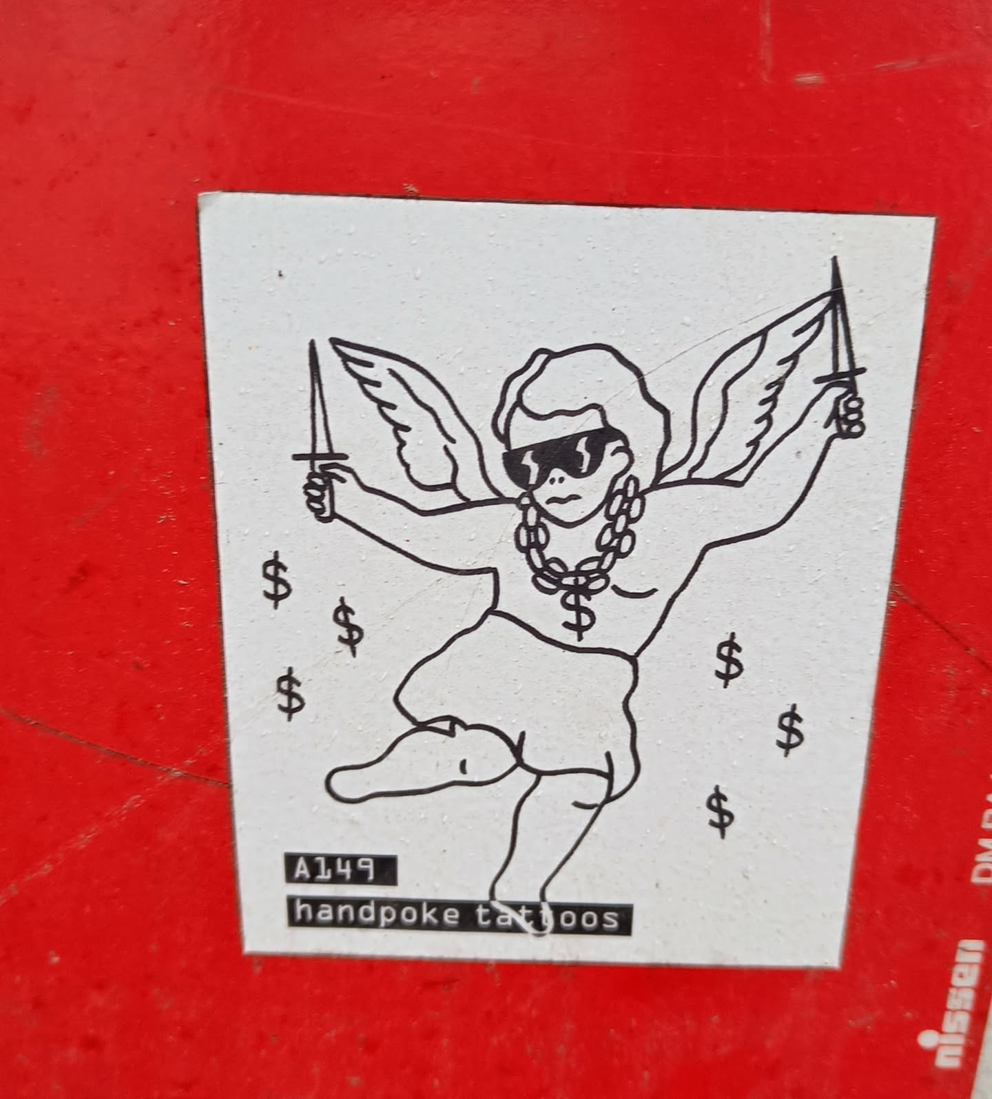 Sticker featuring a cherubic figure with wings, sunglasses, and a dollar sign chain, wielding daggers. The style is reminiscent of handpoke tattoos.