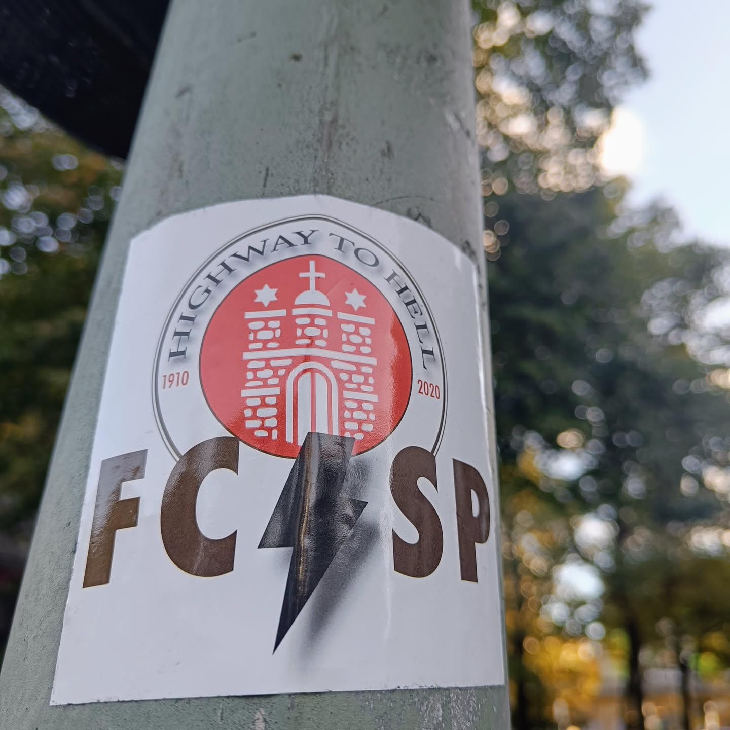 A sticker featuring the logo of FC St. Pauli, a German football club, with the words "Highway to Hell" and the years 1910 and 2020.  A lightning bolt is also depicted on the sticker.