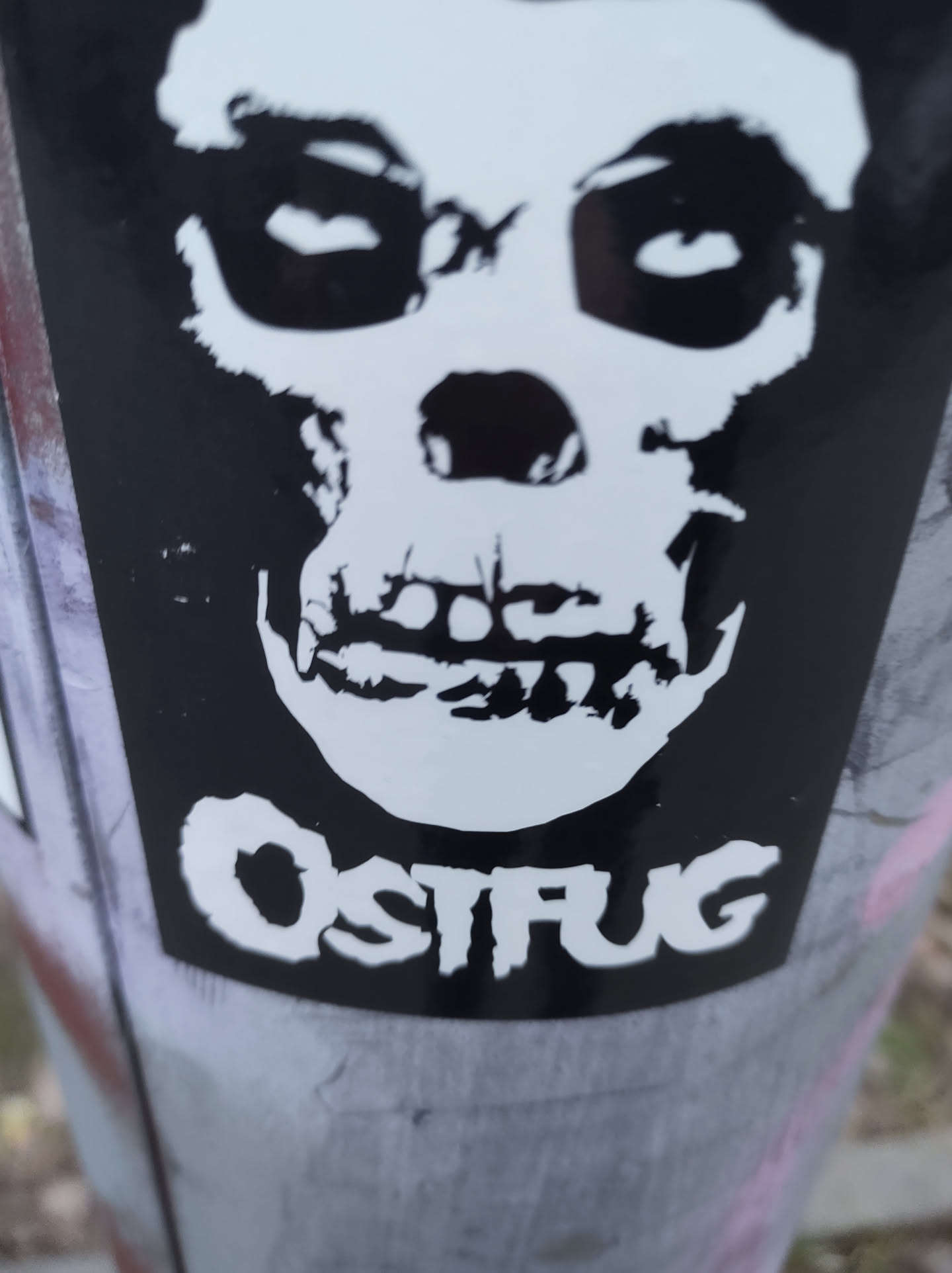 Black and white sticker featuring a Misfits-inspired skull graphic with the word "OSTFUG" written beneath it.