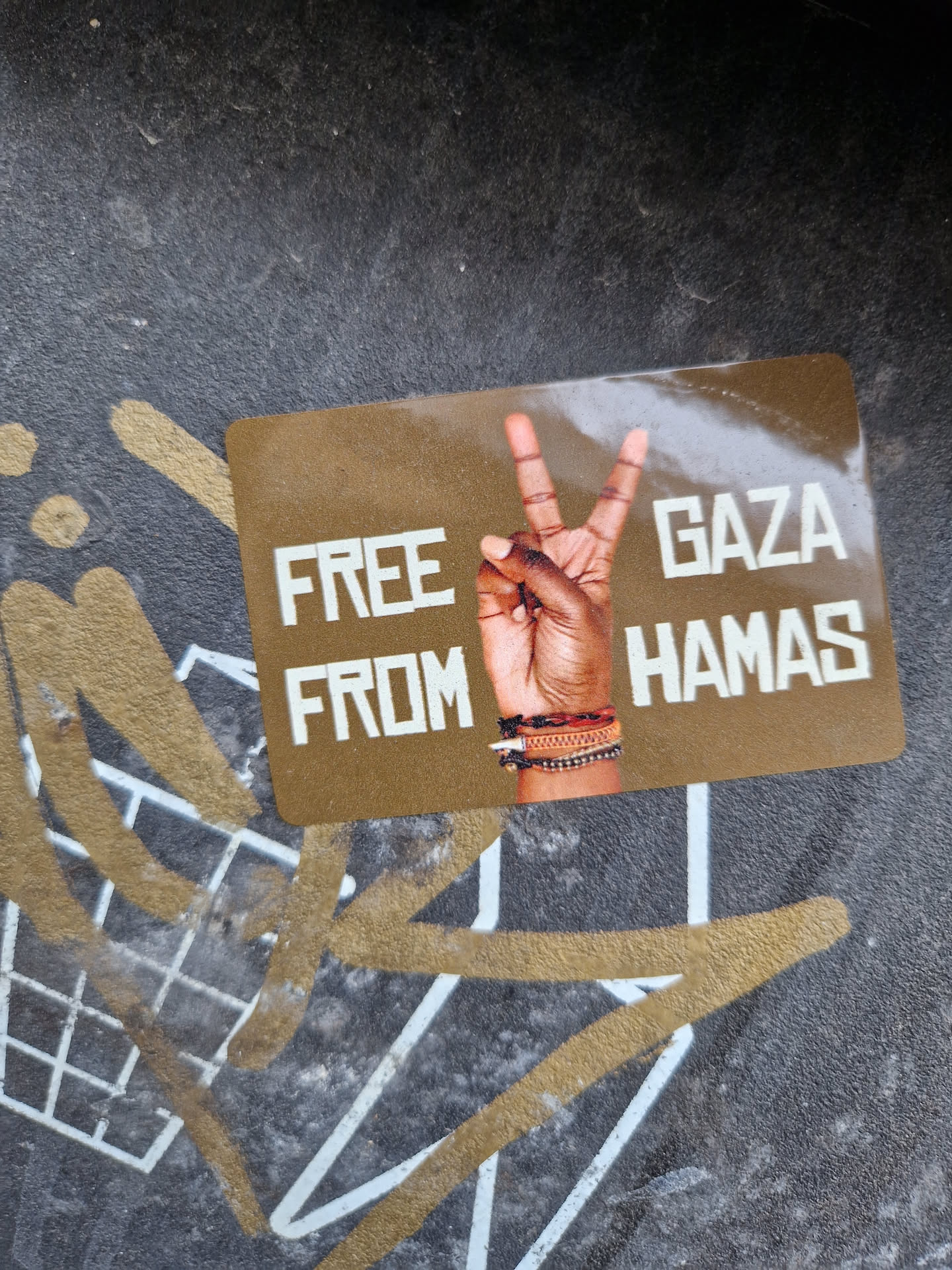 A sticker with a peace sign and the text "Free Gaza from Hamas". The background is gold and the text is white.