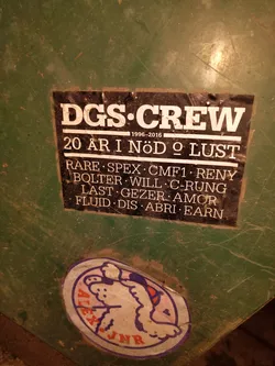 A sticker commemorating 20 years of the DGS Crew, listing crew members' names.  The years 1996-2016 are also indicated, along with the phrase "20 år i nöd o lust" which translates from Swedish to "20 years in need and lust".