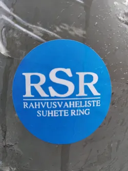 A blue circular sticker with the acronym RSR and the text "Rahvusvaheliste Suhete Ring" (International Relations Ring) in white.