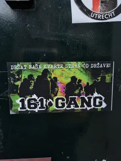 Street sticker A sticker with a graphic design showing a group of people at night with a vibrant color scheme. The text '161 GANG' is prominently displayed in bold, uppercase letters.  The smaller text at the top says 'DRŽAT NAŠE KVARTE STRAN OD DRŽAVE!' which translates to 'Keep our neighborhoods away from the state!' in Croatian.