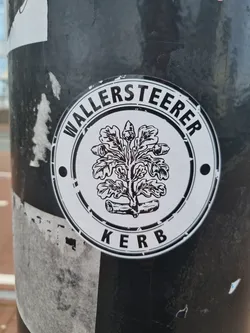 Black and white round sticker with the text "WallerSteer Kerb" and an illustration of an oak tree with acorns in the center. 