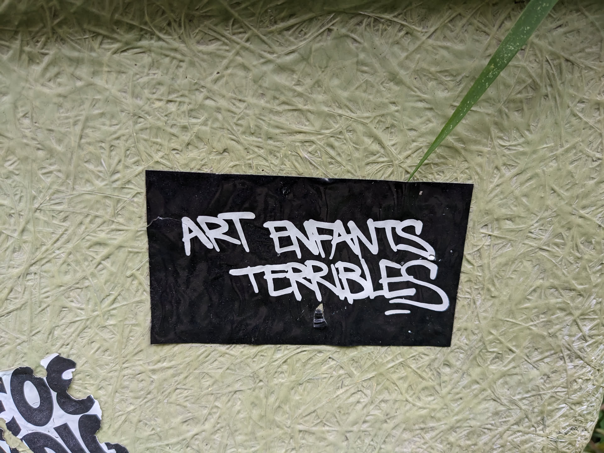 Black sticker with white graffiti-style text. The text says "Art Enfants Terribles".