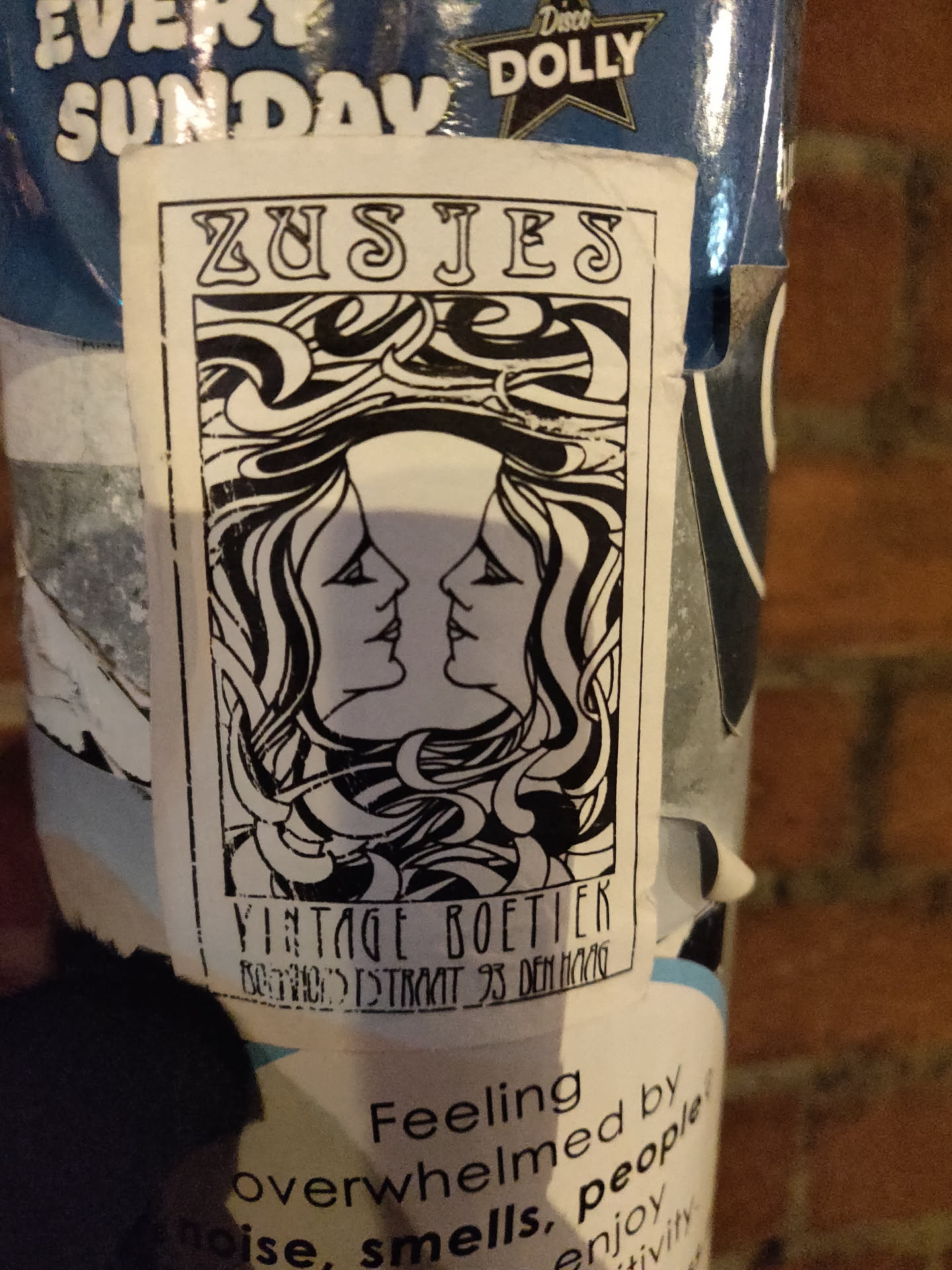Black and white sticker with an art deco design featuring two women's faces. The text on the sticker says "ZUSJES" at the top and "VINTAGE BOETIEK" at the bottom.  There's also some illegible smaller text under the shop name. 