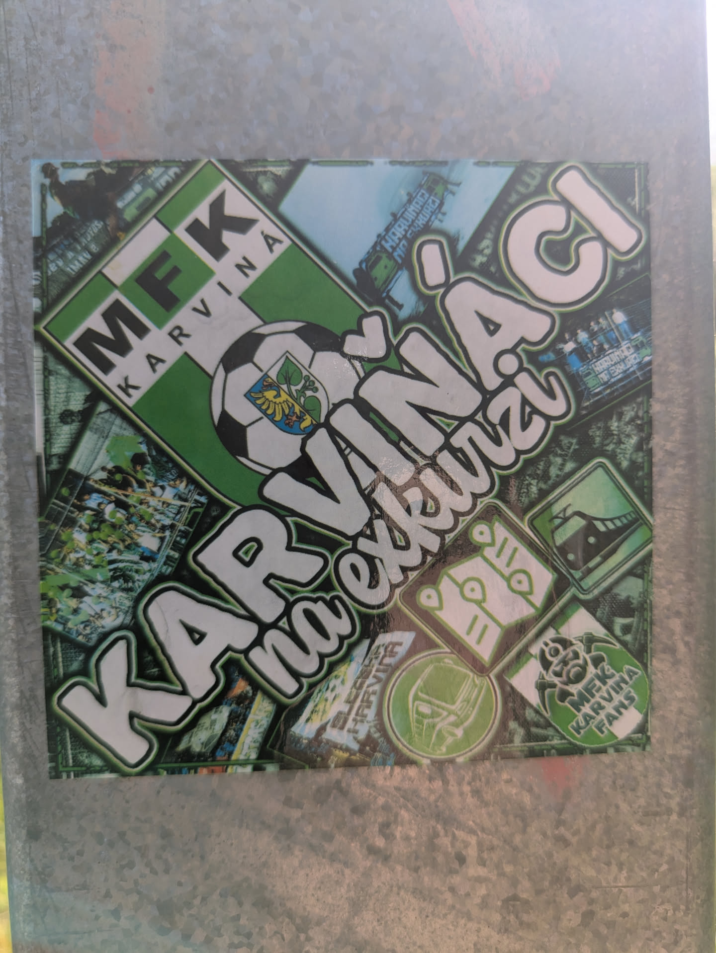 This rectangular sticker features a collage-style design primarily in green, white, and black, centered around the MFK Karviná football club. The most prominent text reads "KARVIŇÁCI na exkurzi" (Karvina people on excursion/trip) in large white bubble letters with a green outline. In the top left, the MFK Karviná club logo is displayed. The background consists of various smaller images and icons related to fan travel and the club, including a football with the Karviná city crest, a bus, a train, and symbolic route pins. Another small badge in the bottom right corner features a mascot and the text "MFK KARVINÁ FANS," reinforcing the theme of fan support and away game travel.