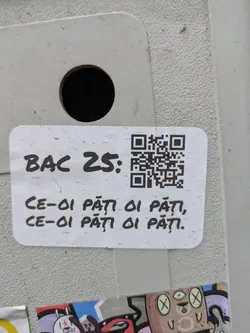 A white sticker with a QR code and text 'BAC 25:' followed by the Romanian phrase 'CE-OI PĂȚI OI PĂȚI, CE-OI PĂȚI OI PĂȚI.'