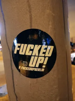 Round black and white sticker with the text "FUCKED UP!" in bold capital letters.  Below the text is a hashtag: #fuckedupperberlin and an Instagram icon.