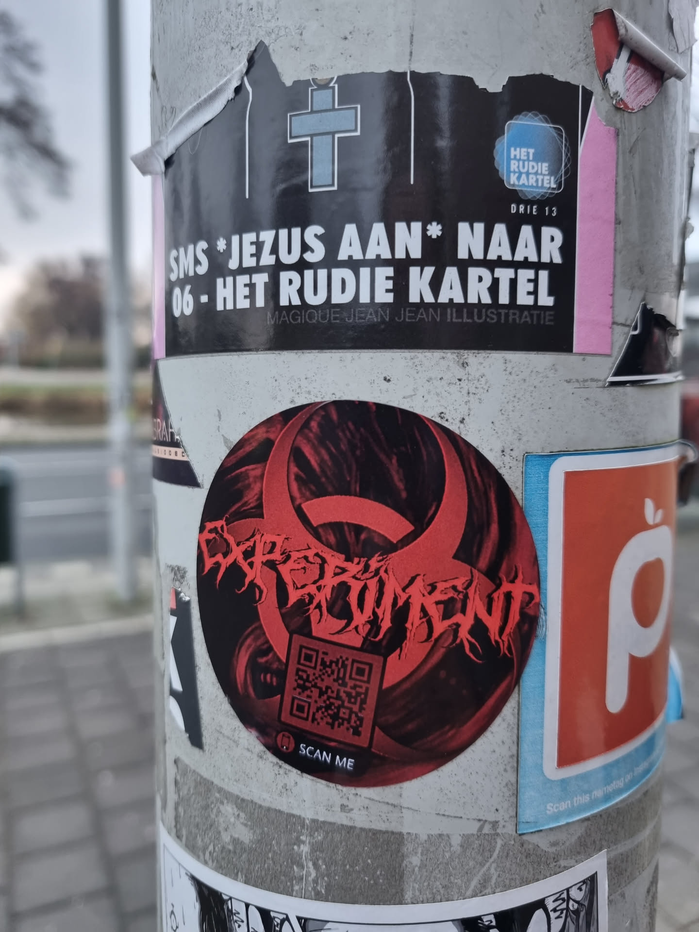 Red and black sticker with the word experiment in a stylized font. It includes a QR code at the bottom. The background is dark with red accents.