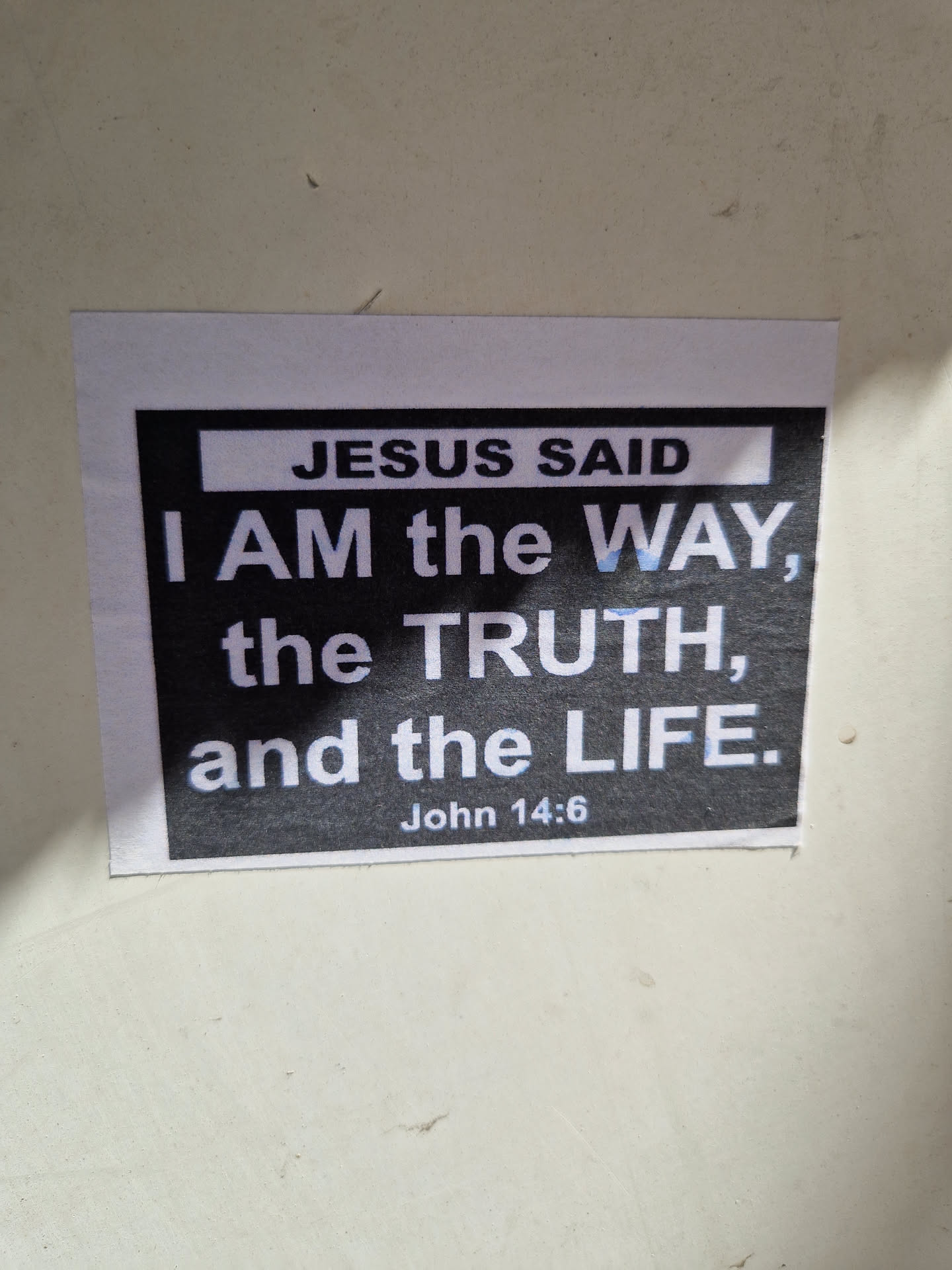 A religious sticker with a quote from John 14:6. The sticker has a black background with white text.