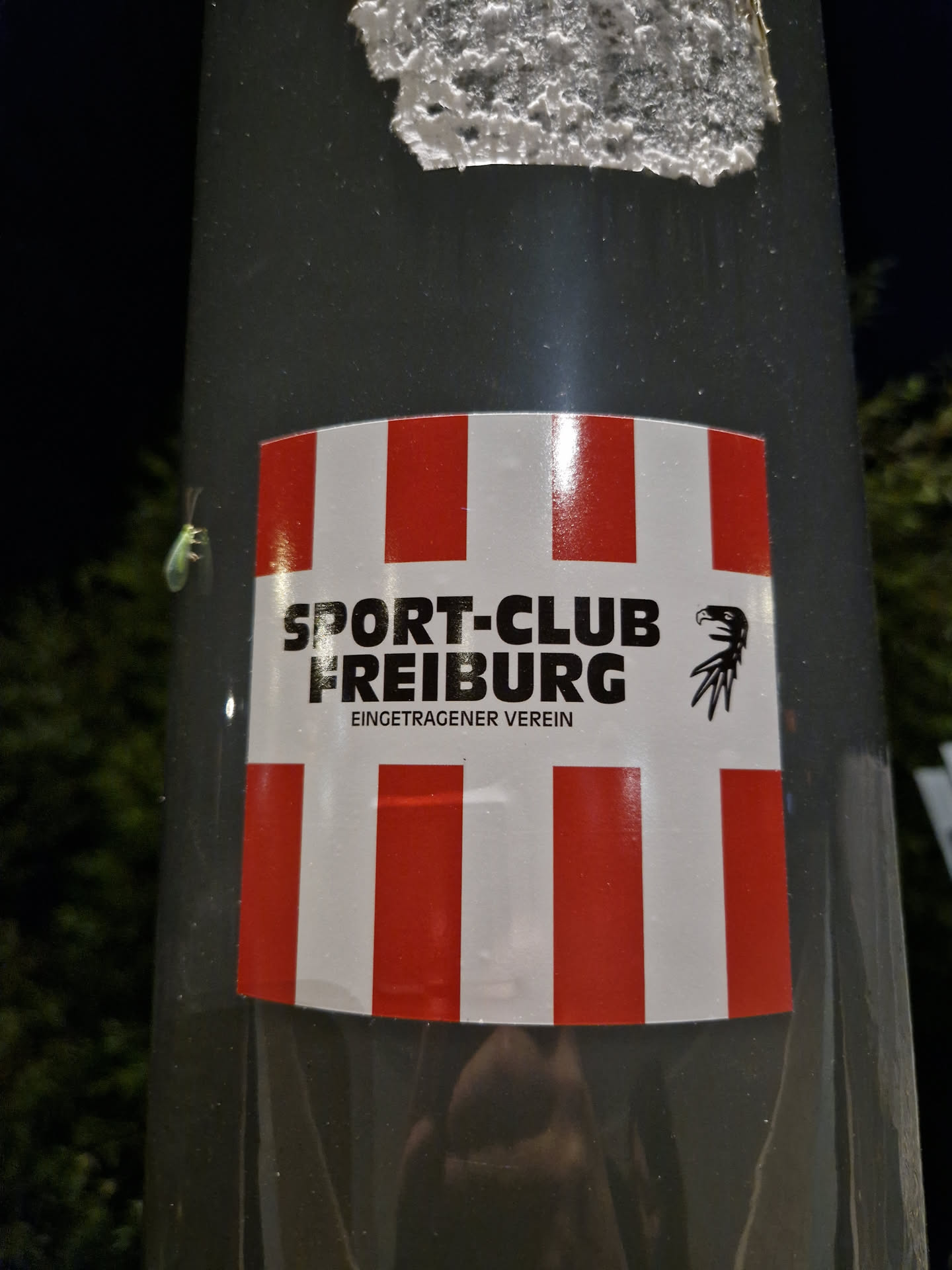 A sticker featuring the logo of Sport-Club Freiburg, a German football club. The sticker has a red and white striped design and includes the text "Sport-Club Freiburg" and "eingetragener Verein" (registered association).