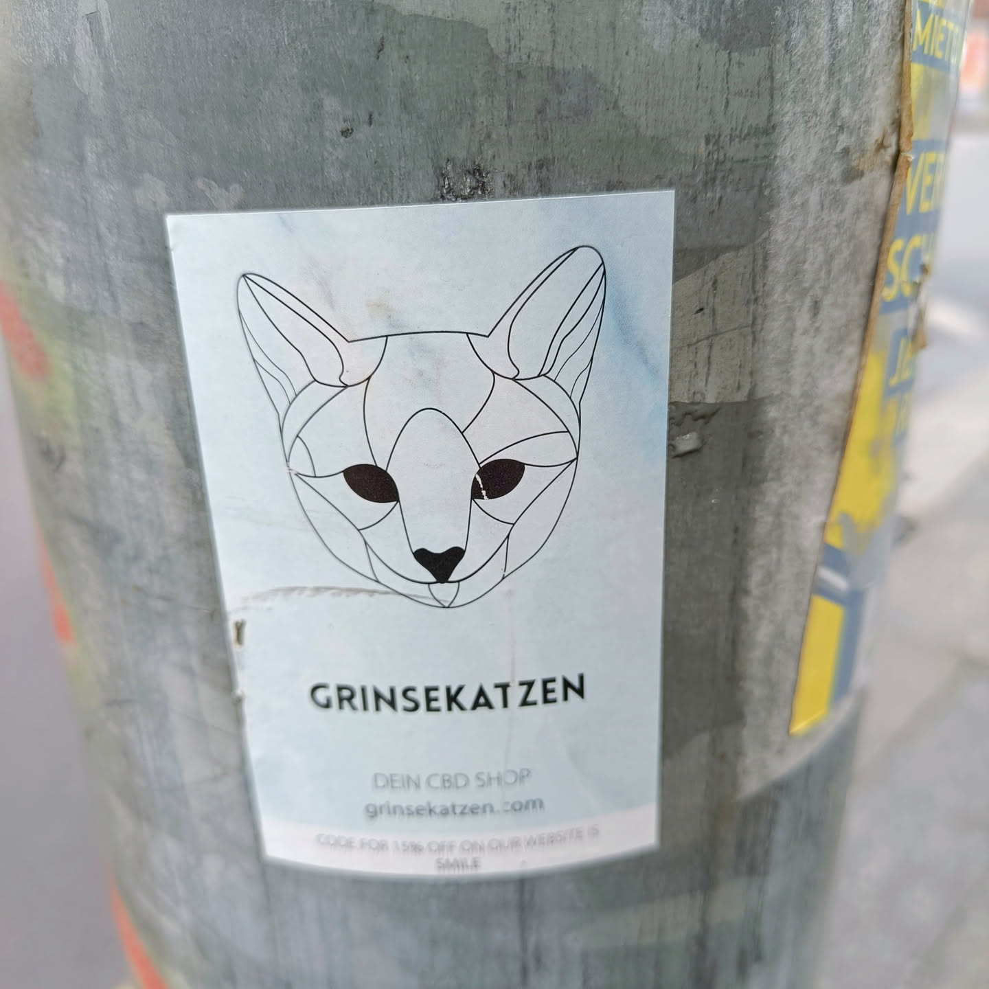 Sticker featuring a geometric cat design and the text 'Grinsek Katzen' with the tagline 'Dein CBD Shop' and website address grinsek Katzen.com.  It also includes a code for 15% off.