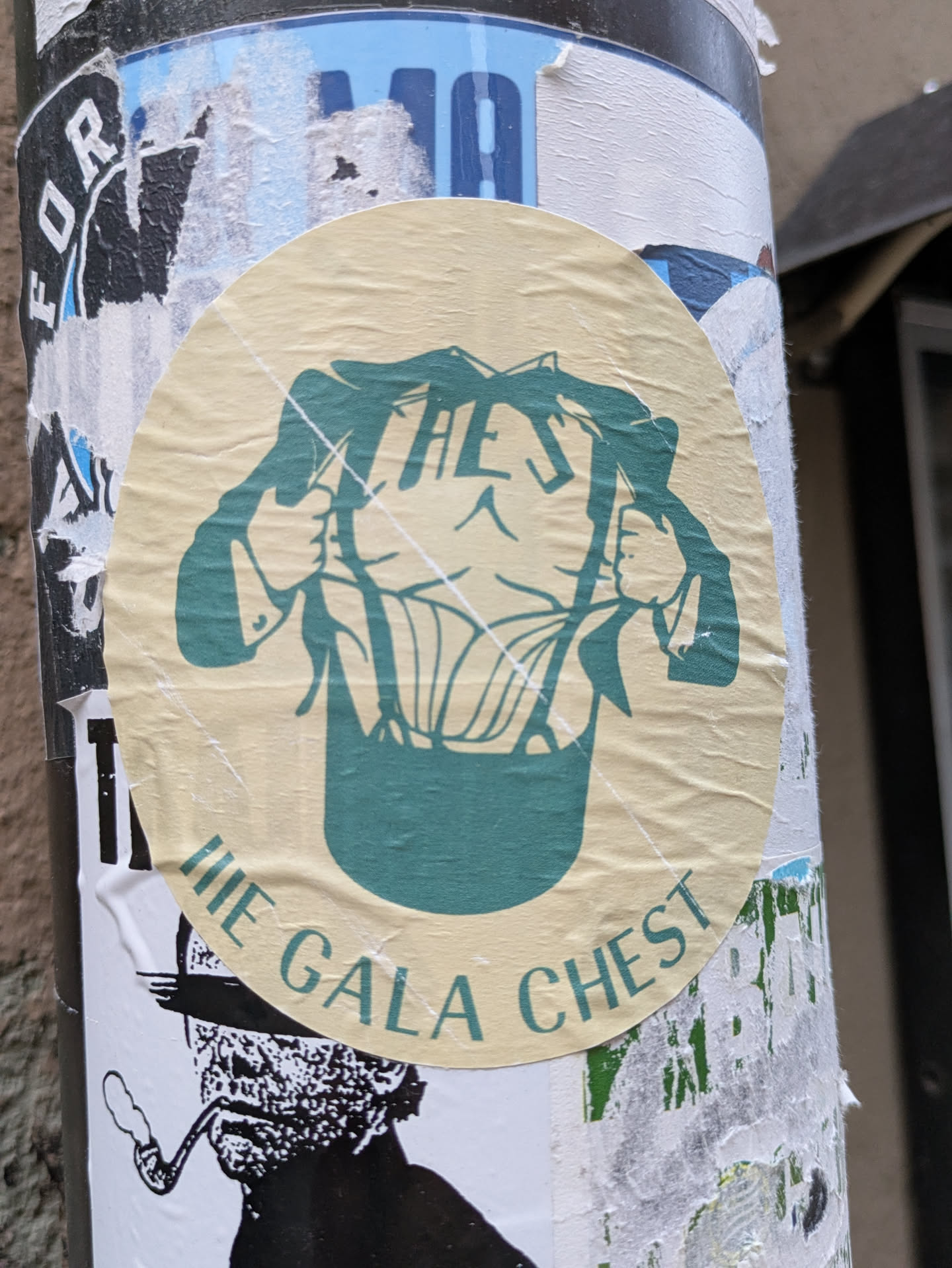 A round sticker featuring an illustration of a person ripping open their jacket to reveal a large chest. The text "The Gala Chest" is written around the illustration. 