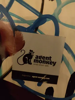 A sticker featuring a monkey wearing a hat, with the text 'agent monkey' and the tagline 'small smart safe'.  A website address and hashtag are also included.