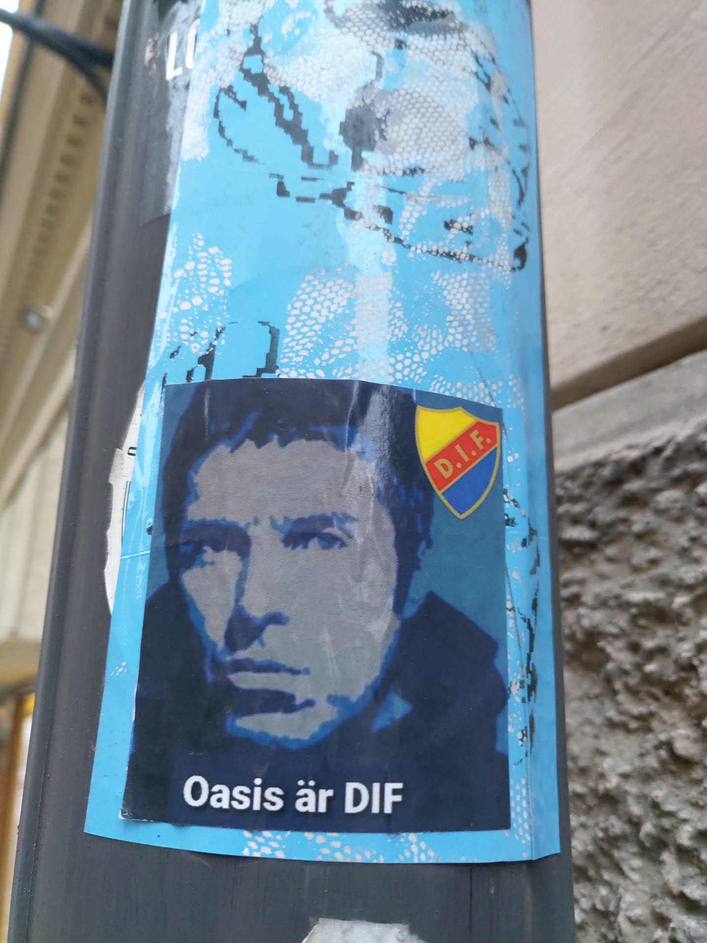 A sticker featuring a stylized portrait of Liam Gallagher, the lead singer of Oasis, superimposed over a blue background.  A crest with the initials "D.I.F." is also present. The text at the bottom translates from Swedish to "Oasis is DIF".