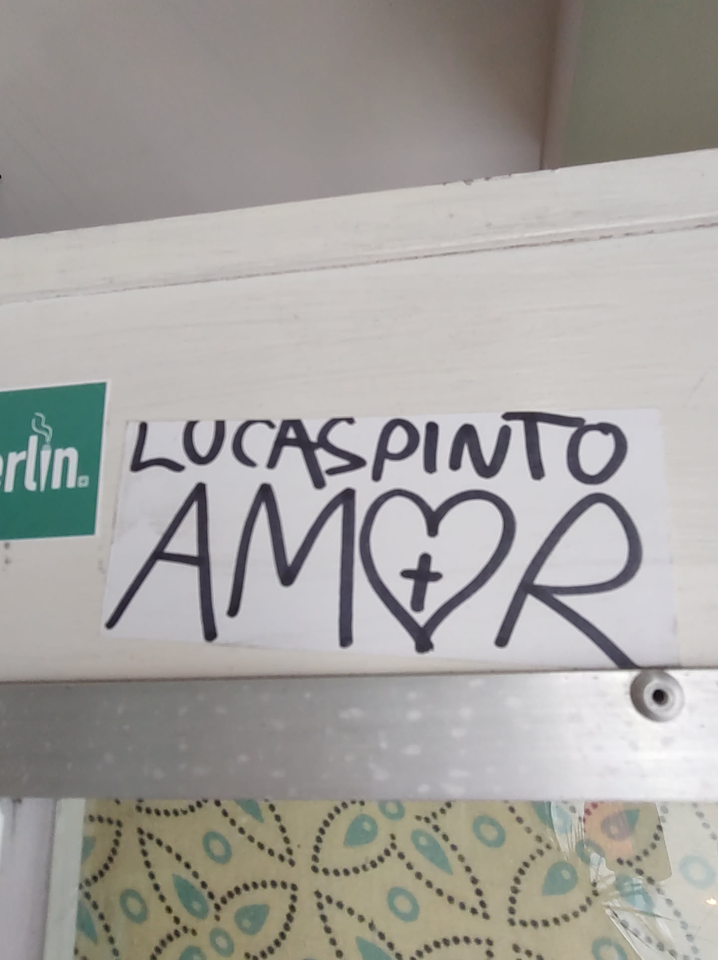 A sticker with the name Lucas Pinto and the word Amor (love) with a heart and cross.
