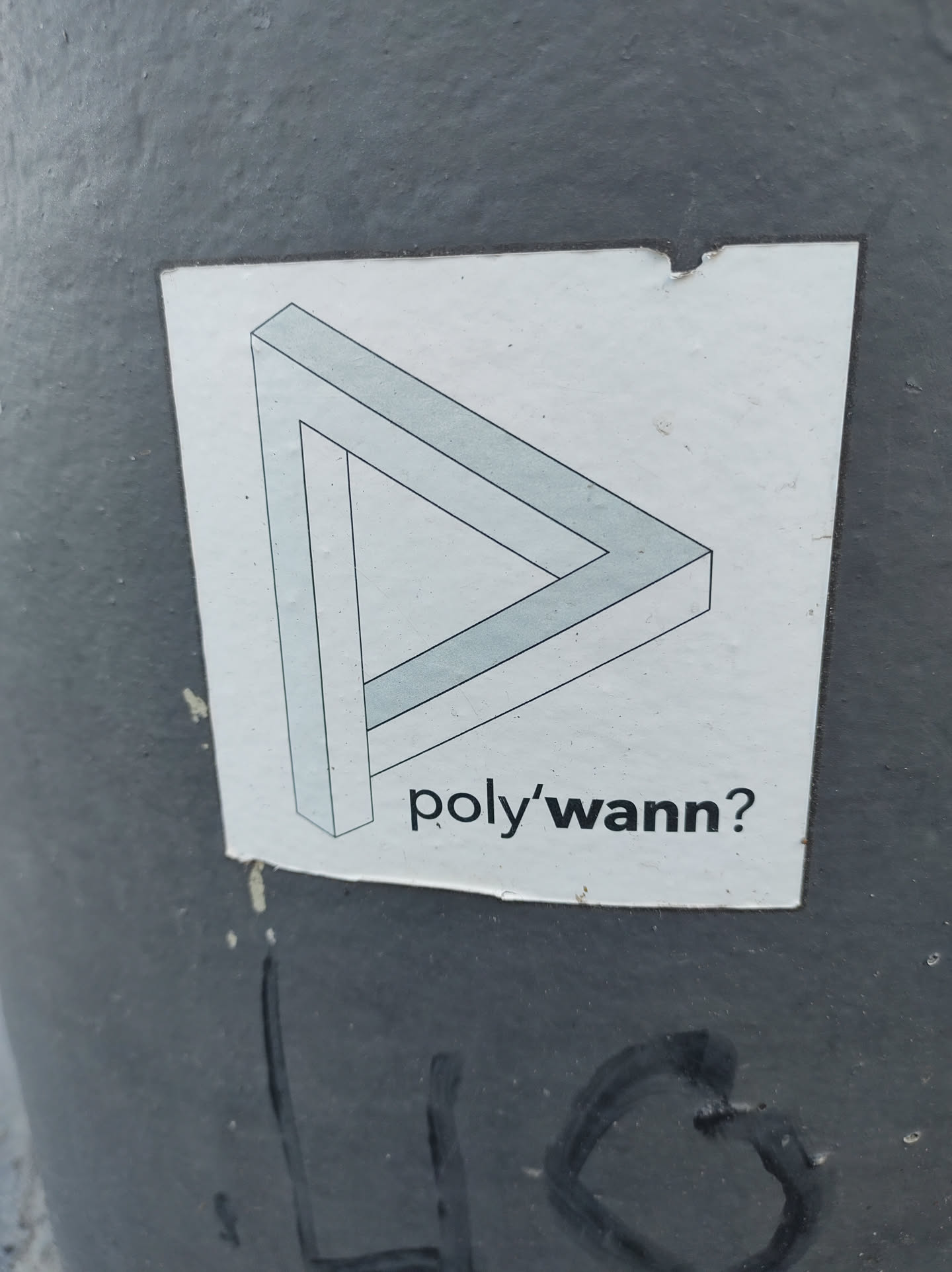 A sticker featuring a Penrose triangle illusion with the text 'poly'wann?' below it.