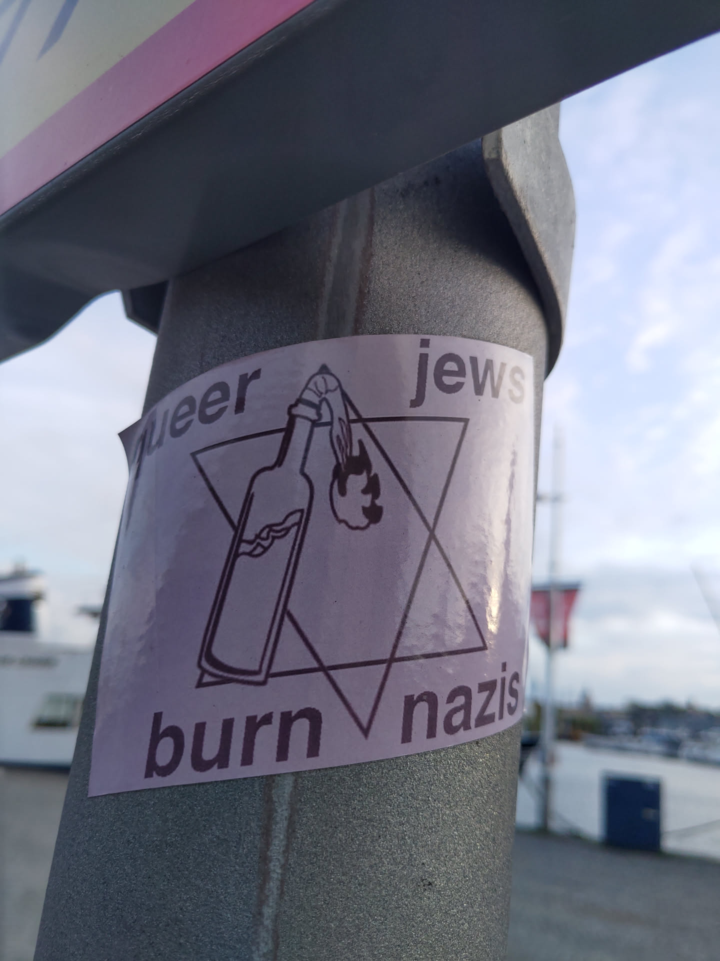 A sticker depicting a Molotov cocktail inside a Star of David with the text "Queer Jews Burn Nazis".